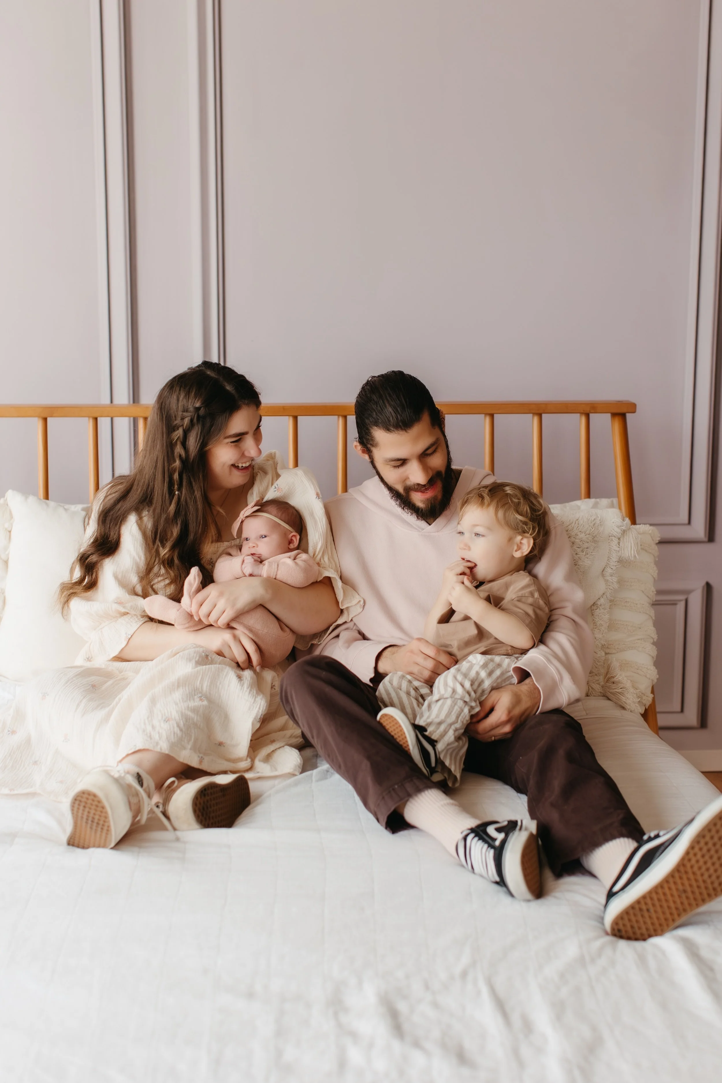 Family photo cuddling on bed during a baby photography session