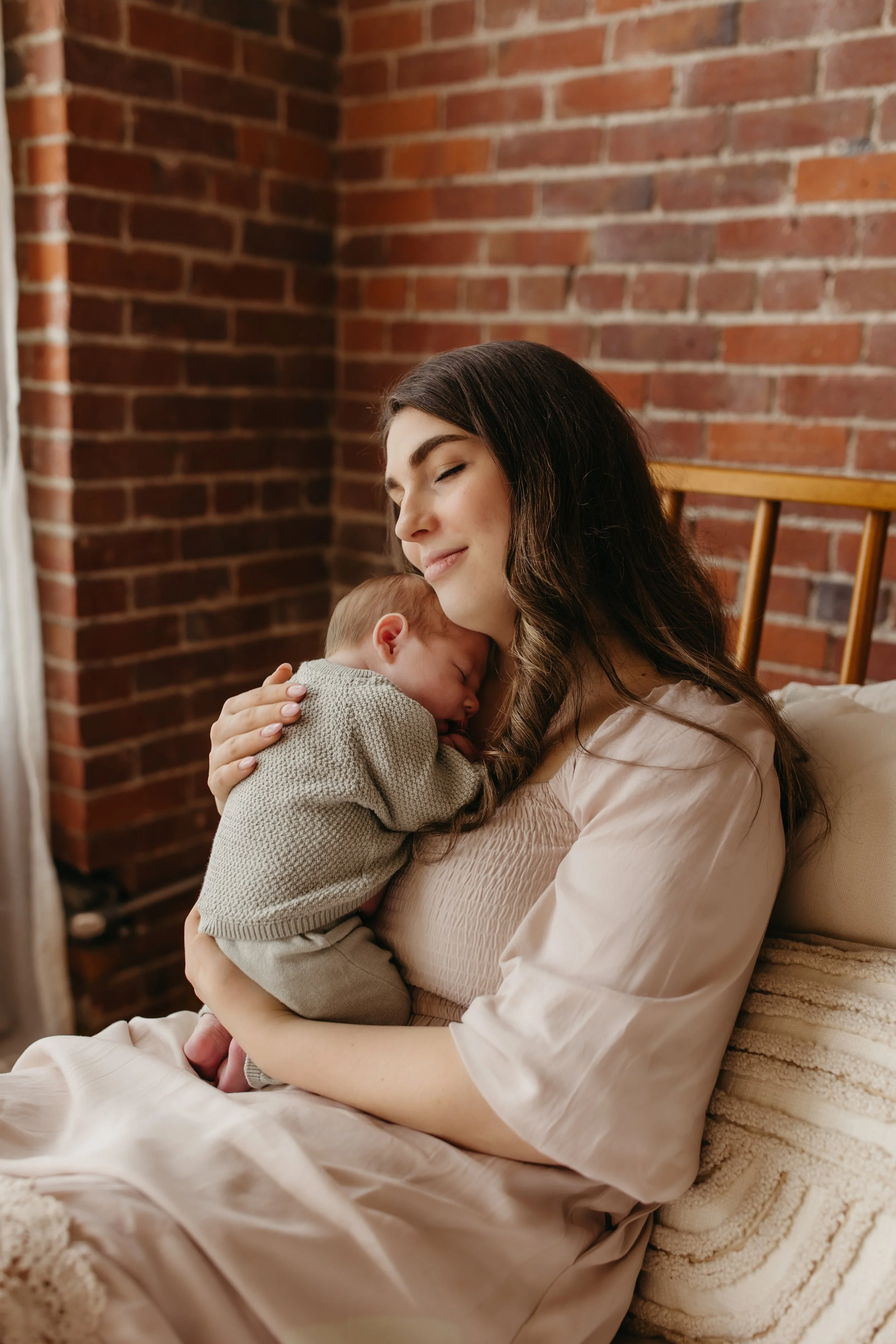 newborn baby snuggling in new mom's arms in Seattle