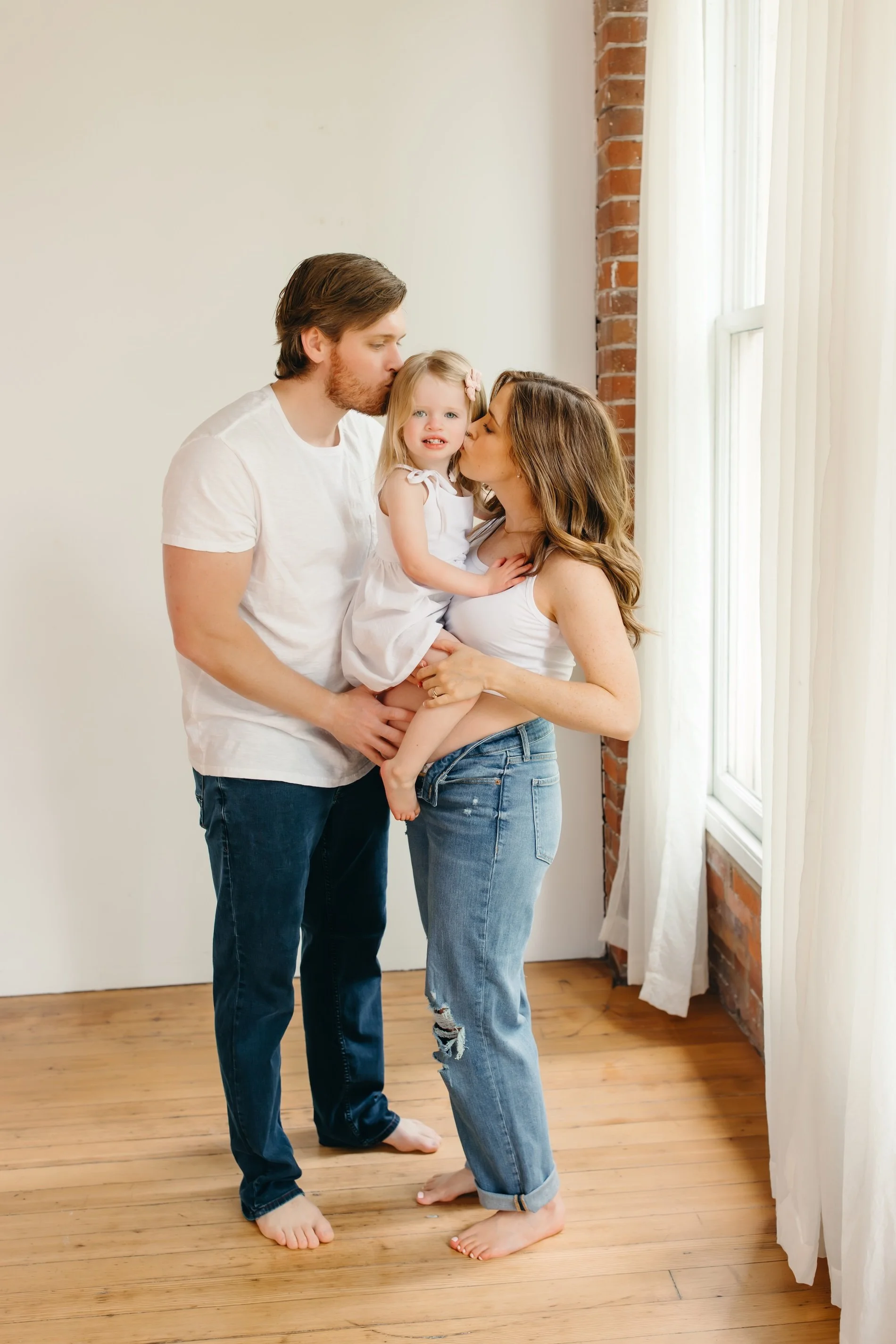 Maternity photo of family of three in bright photo session