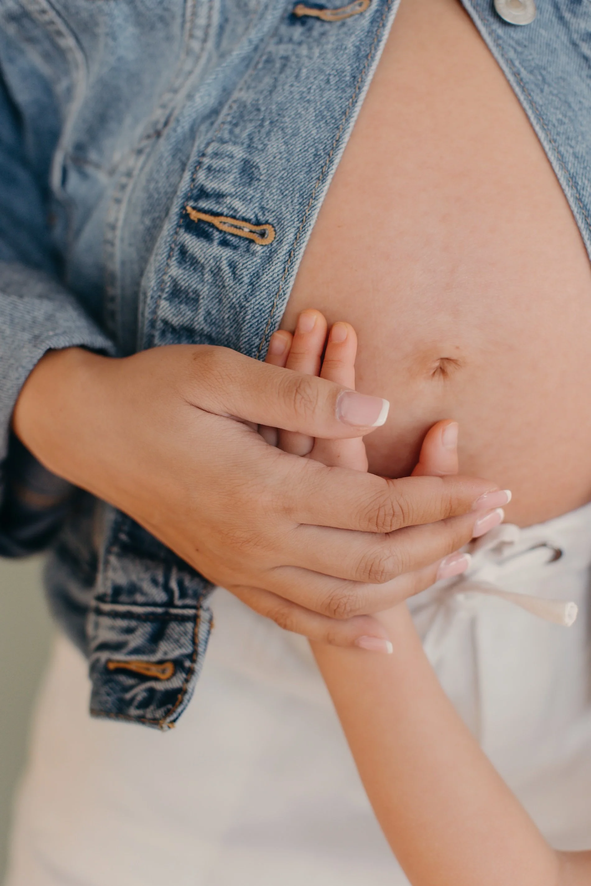 Tender image of toddler holding pregnant mom's baby bump