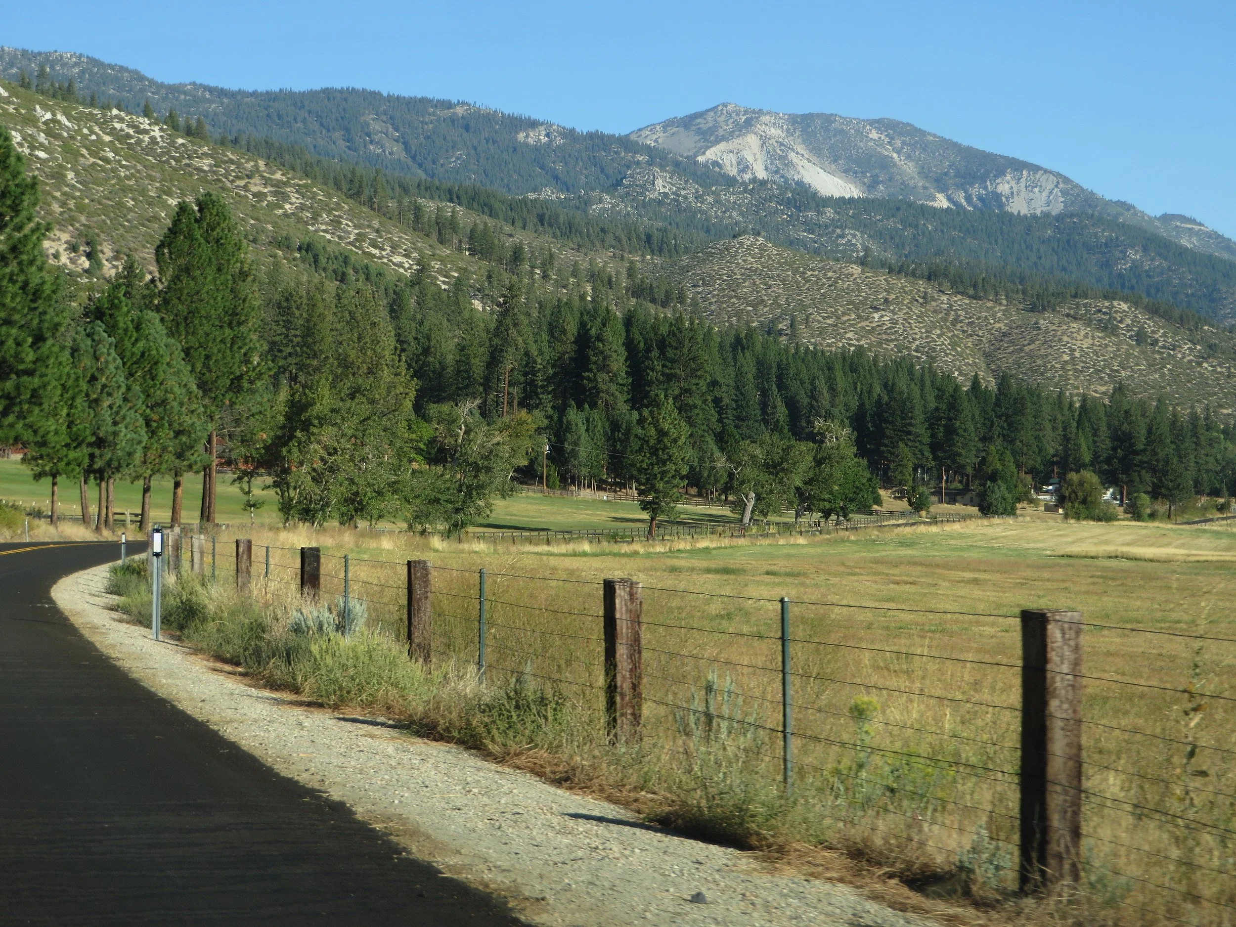 Scenic road through Washoe Valley with open fields and mountain views