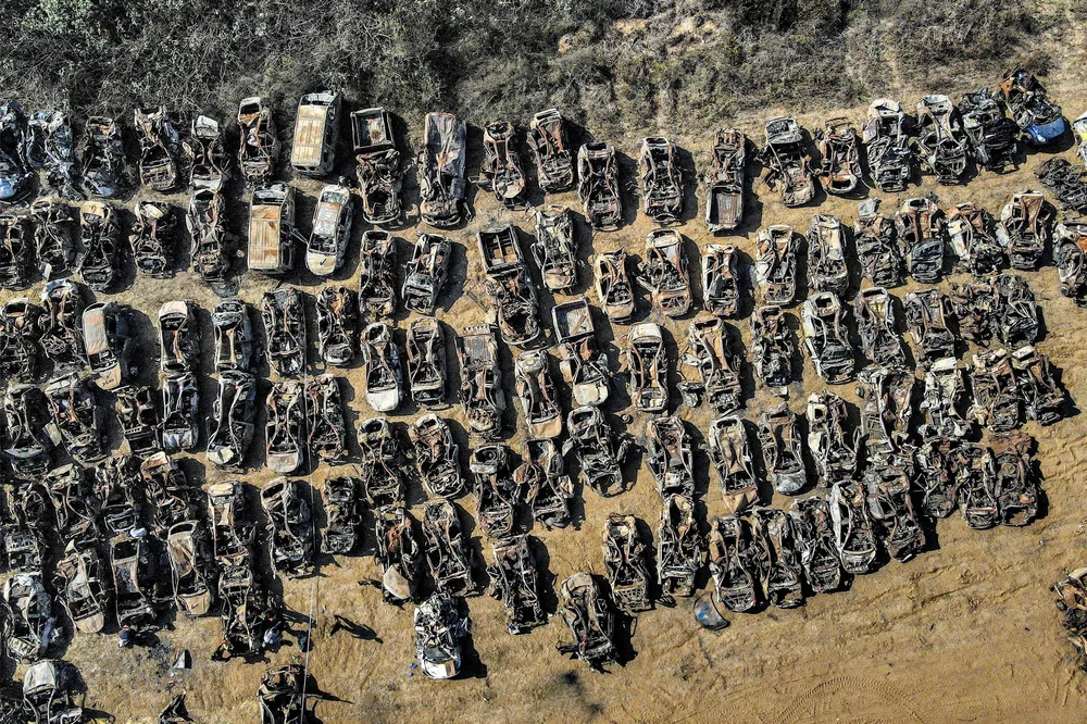   Rows of incinerated vehicles near Re’im, their frames reduced to slag. Forensic experts note that the heat and downward blast signatures are consistent with helicopter or air-to-ground fire, not light weaponry from gliders.  