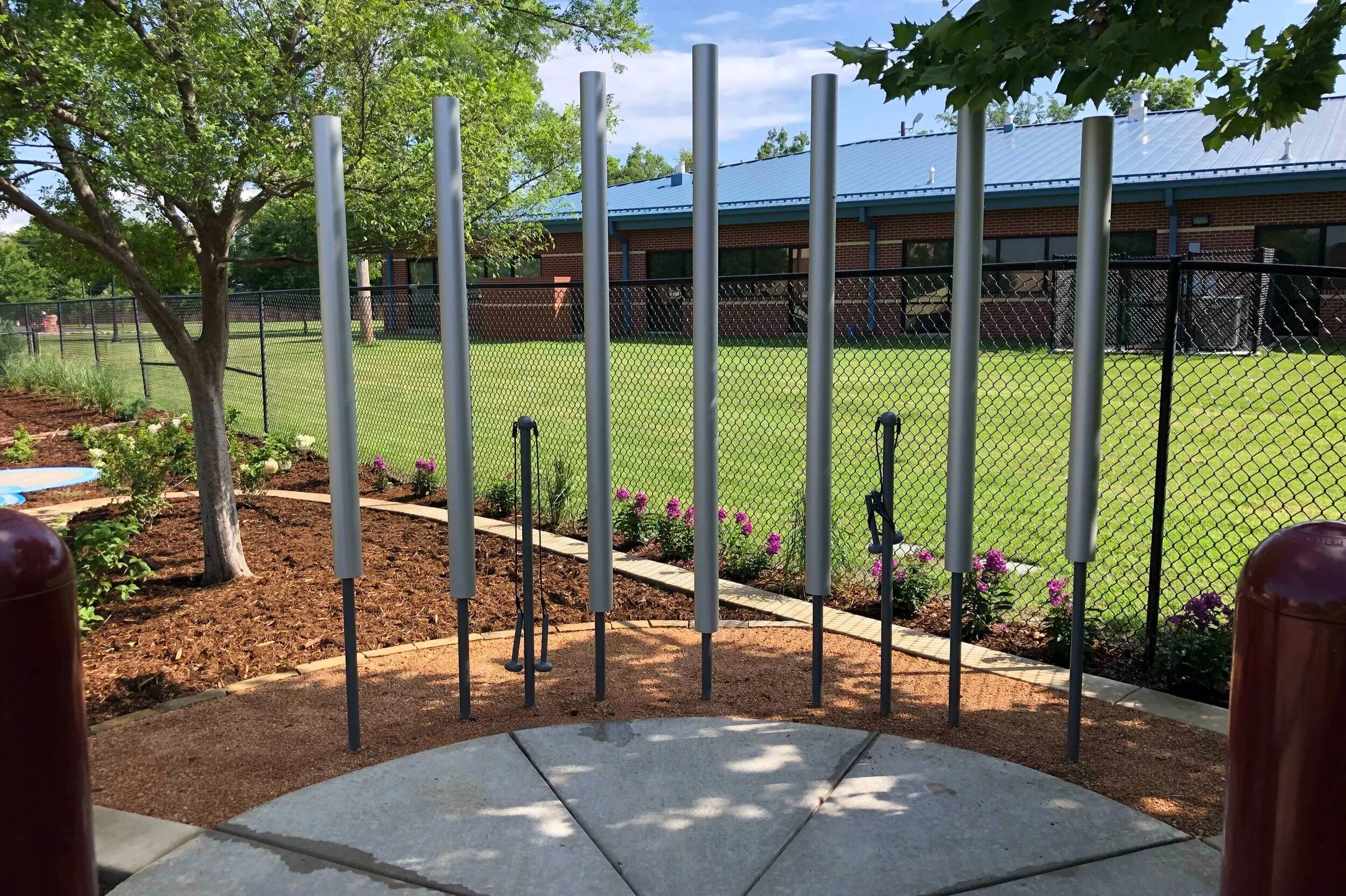 a series of chimes displayed vertically in an outdoor classroom where children can perform
