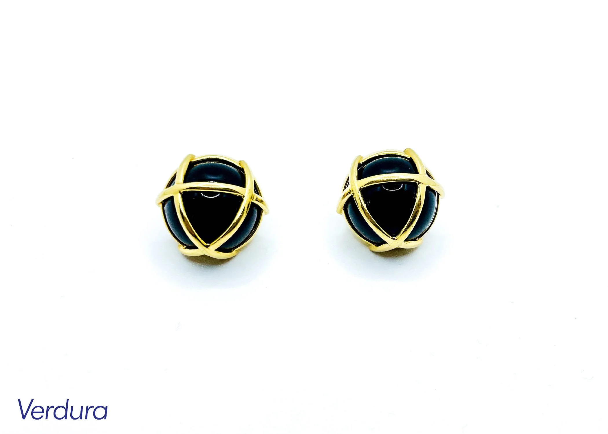 A pair of black and gold earrings with a rounded black stone encased in a gold wire frame, placed on a white background.