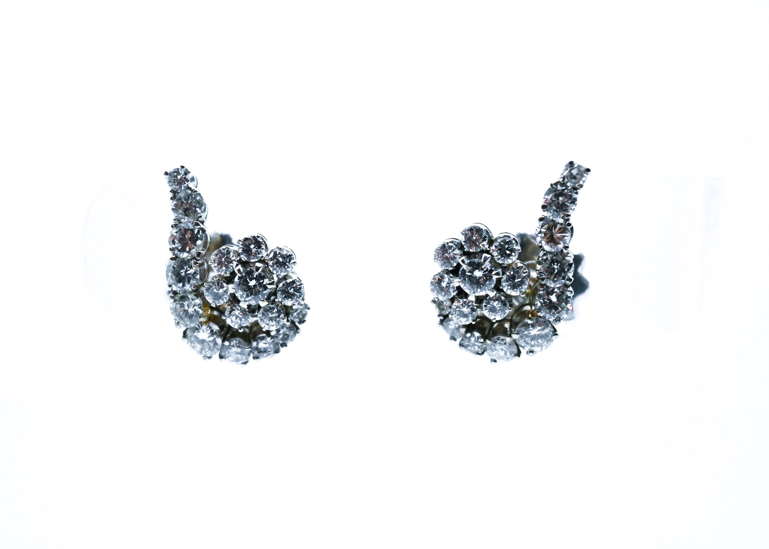 Pair of diamond stud earrings with a cluster of small diamonds at their centers, set in a shiny metal, displayed against a plain white background.