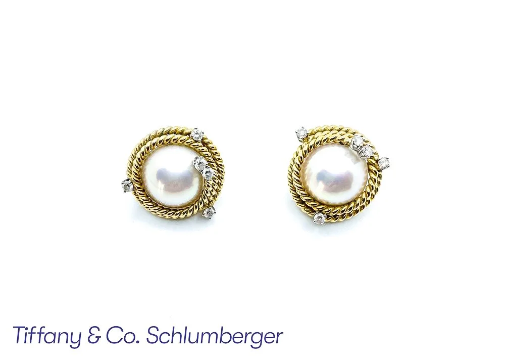 A pair of vintage-style pearl earrings with gold twisted rope borders and small diamonds, displayed on a white background with the text 'Tiffany & Co. Schlumberger' partially visible at the bottom.