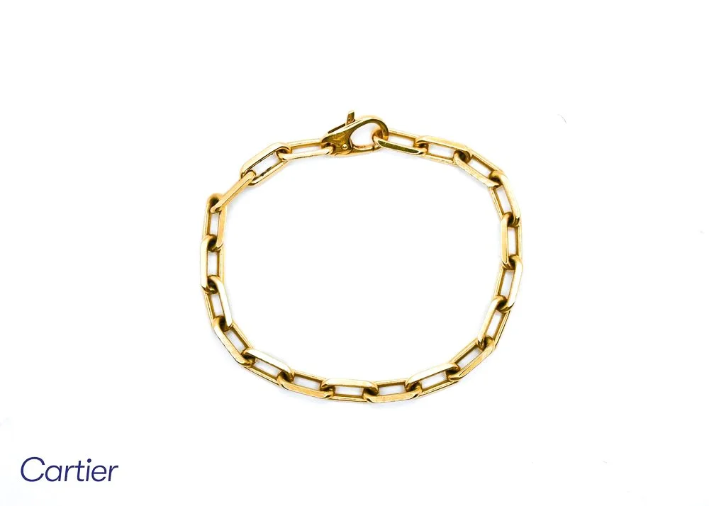 Gold chain bracelet on white background with Cartier branding.
