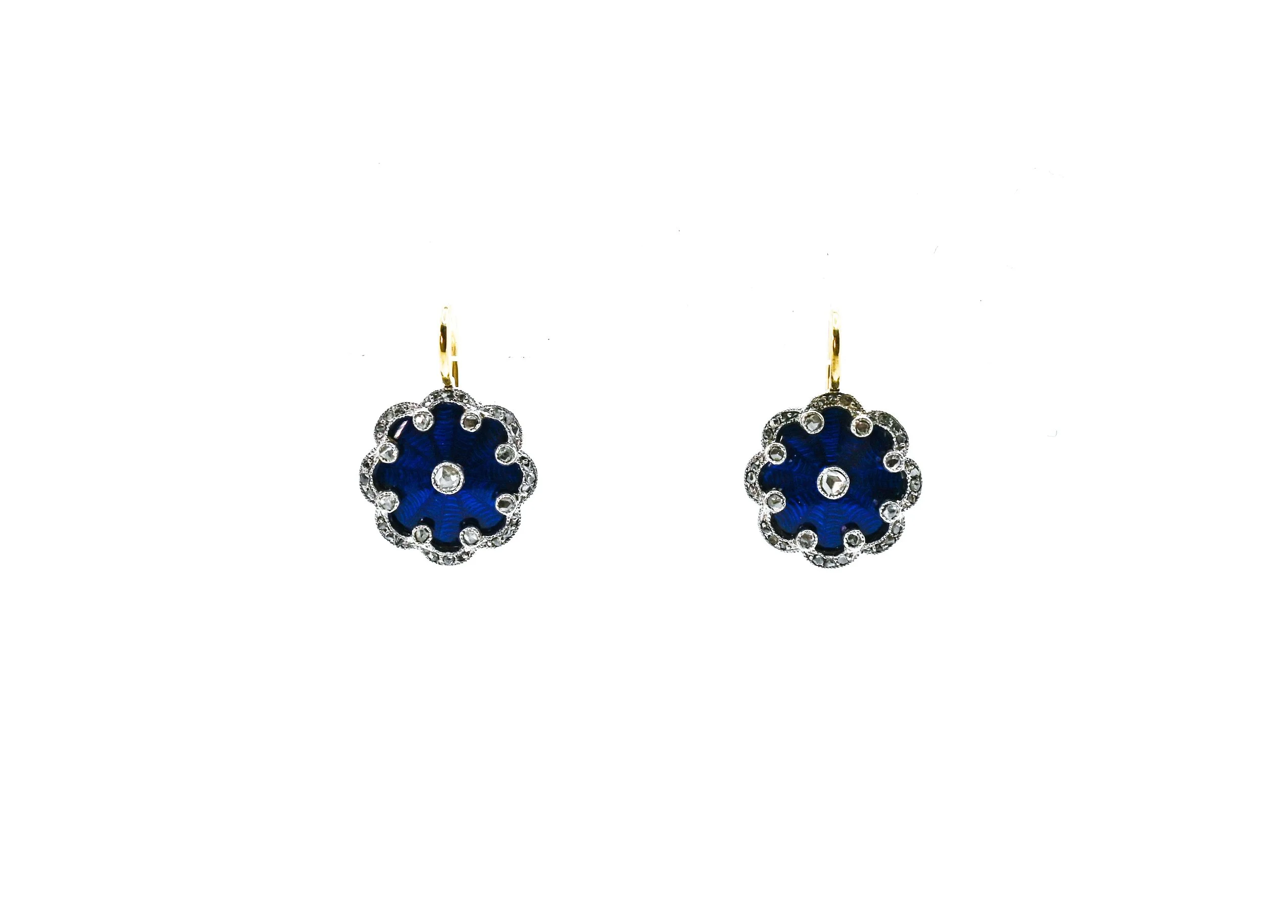 A pair of earrings with blue flower-shaped pendants surrounded by small clear gemstones, hanging from gold hooks.