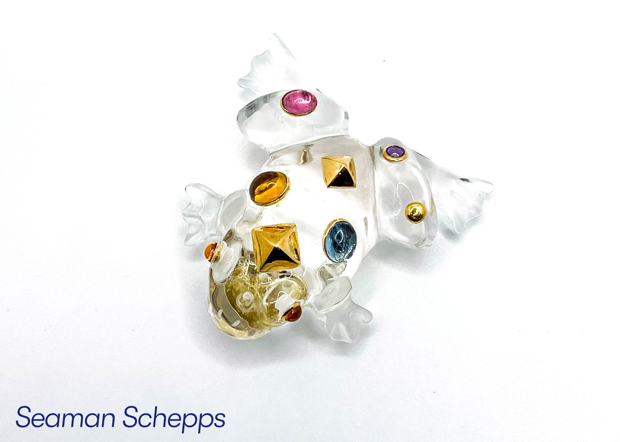 A decorative glass art piece shaped like a star with colorful gemstone embellishments in pink, purple, yellow, and blue, set against a white background.