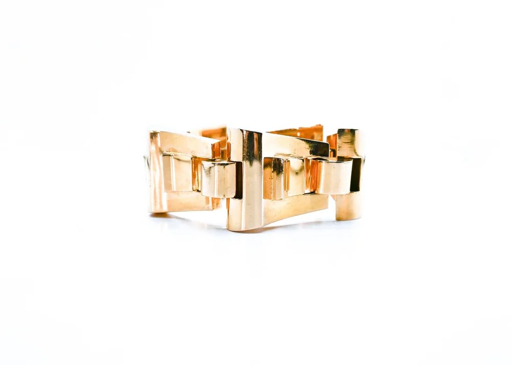 Metal bracelet with rectangular links, gold and black coloring, on a white background.