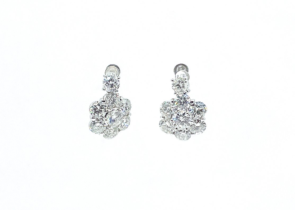 A pair of silver earrings with cluster of clear, round-cut gemstones.