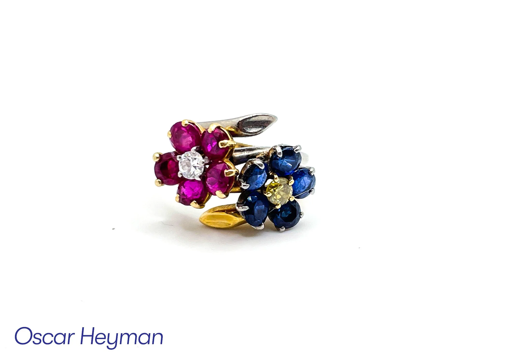 Colorful flower-shaped ring with pink, blue, and yellow gemstones, set in a metal band.