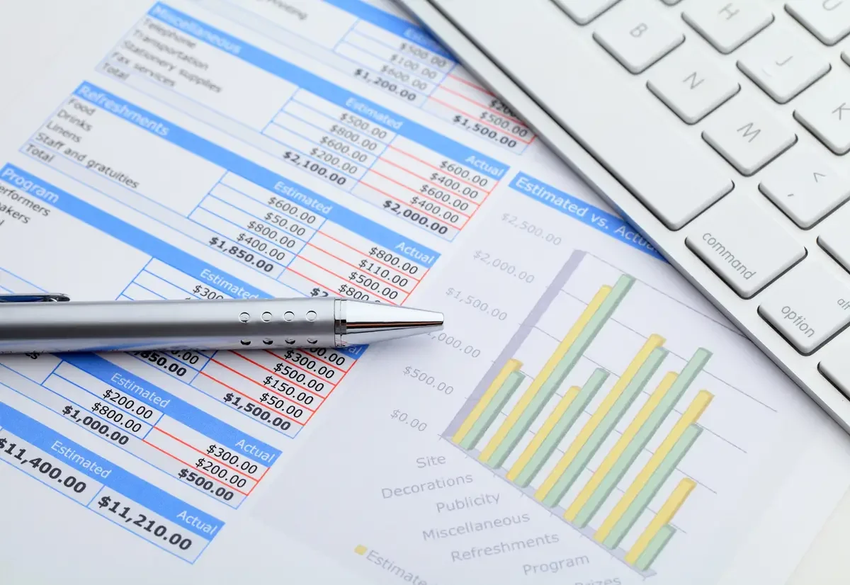 Close-up shot of a pen resting on a financial spreadsheet and bar graph, illustrating a Malaysian SME owner conducting a financial health checkup using key ratios.