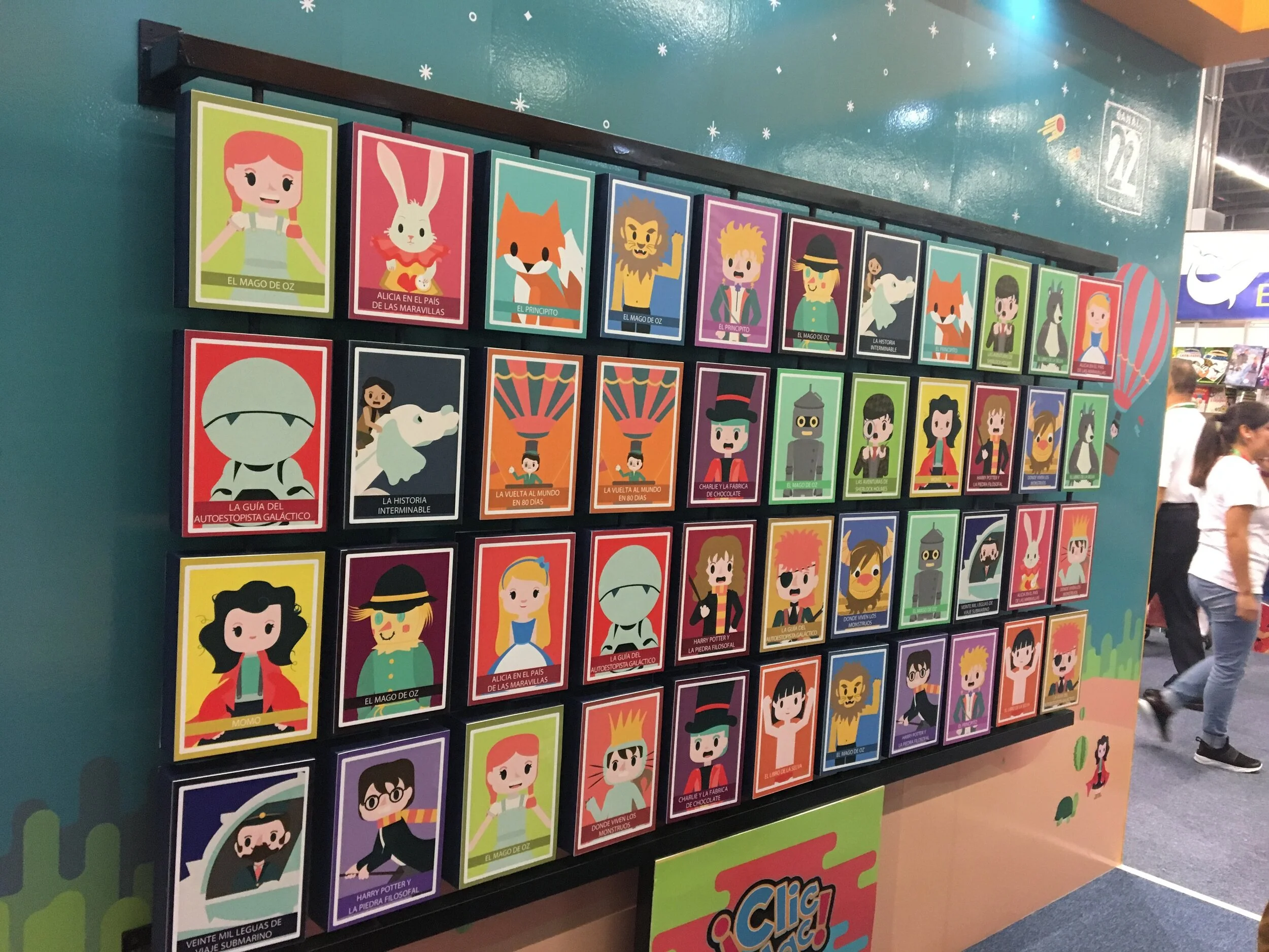 Colorful display of illustrated books featuring characters from 'The Wizard of Oz', a spaceship, a fox, a lion, a horse, and various other stories and characters, each with a distinct title in Spanish.