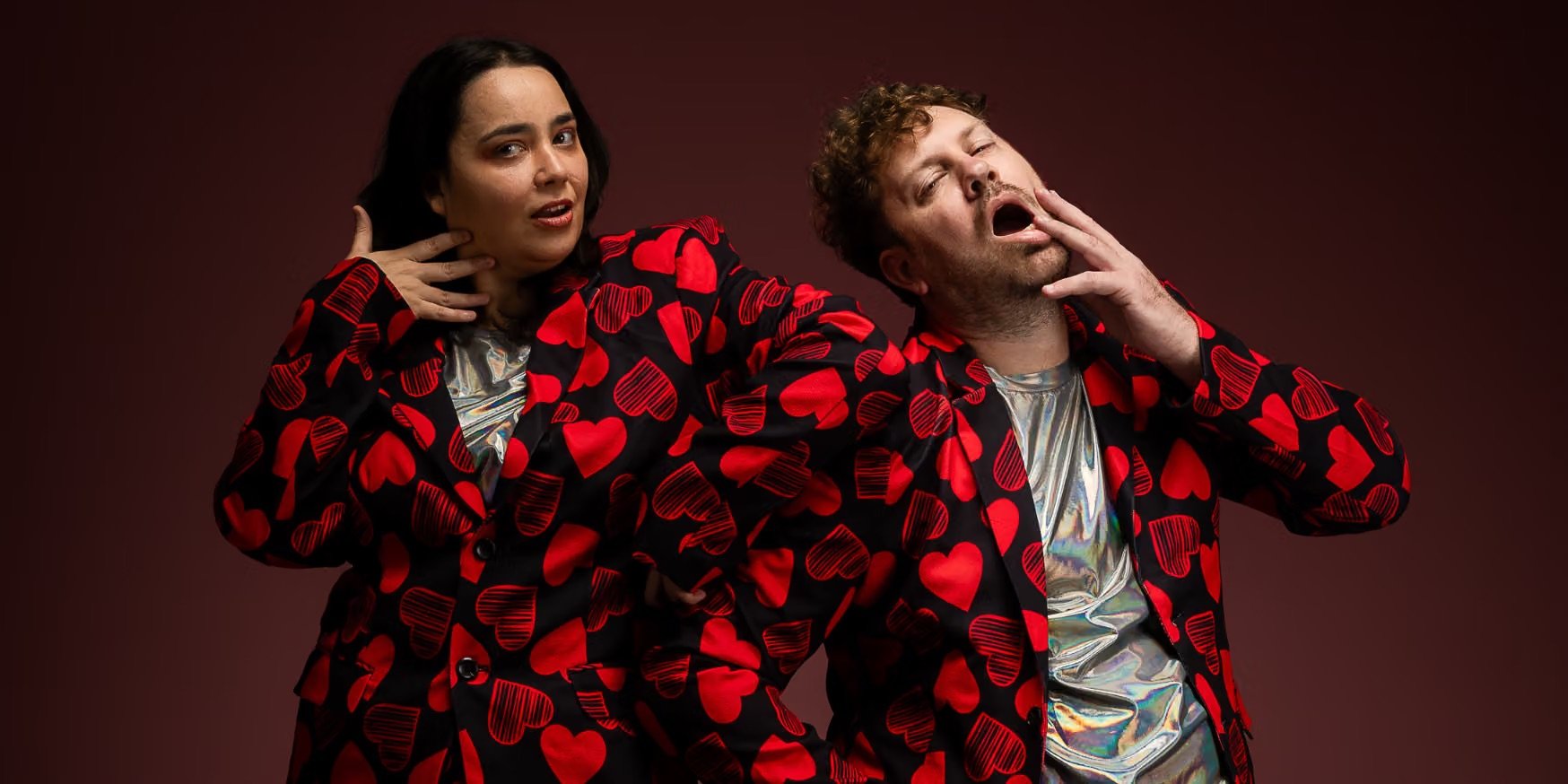 Image of a female and male posing in suits with illustrated love hearts