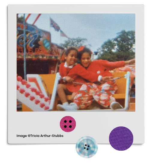  Two young girls sit huddled together enjoying a fairground ride at Bradford Festival and Mela. A portrait of a young performer in a striking pose wearing top hat, reflective sun glasses, a red feather boa and waving decorative paper fans 