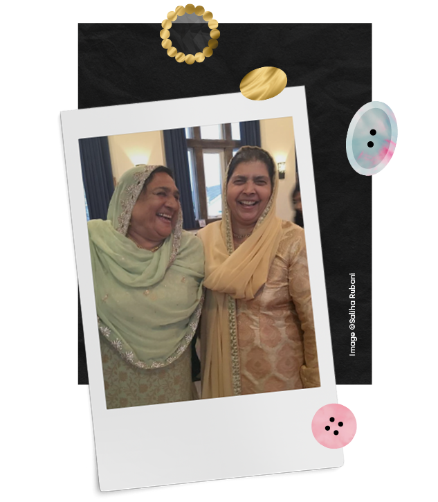  Two women stand side by side, laughing enjoying themselves at a family event. A group of young children at Bradford Museums, pose looking at camera, dressed in victorian costume and holding a doll pose in front of an image of victorian children in B