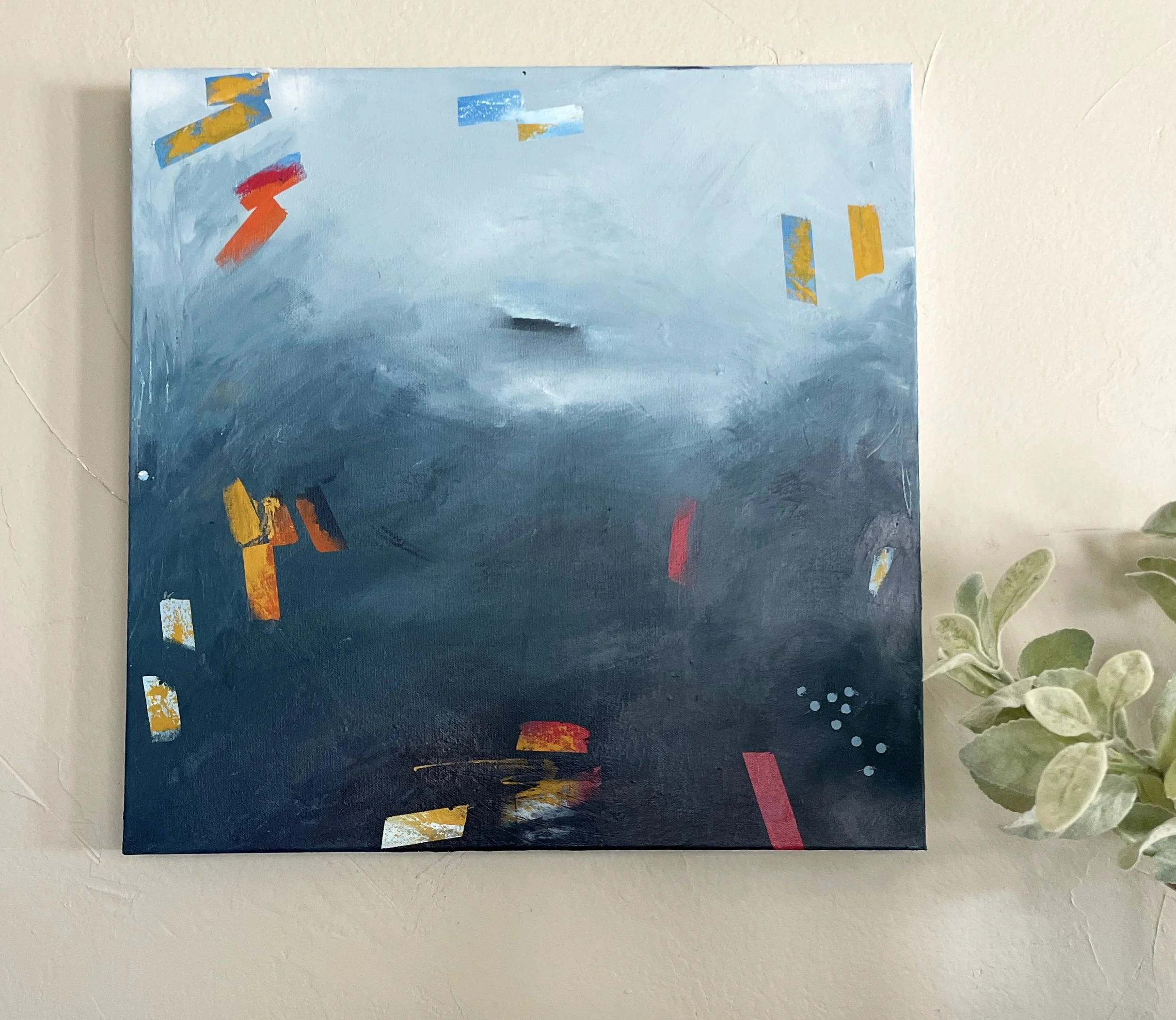 Abstract painting with shades of blue, accented by scattered rectangular patches of yellow, red, and white, and small dotted details on a wall near a green plant.