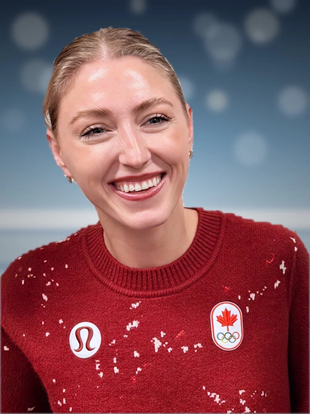 Close-up of a smiling woman wearing a red Canadian Olympic sweater with a maple leaf and Olympic rings logo, and a Lululemon logo, with a blurred blue background.