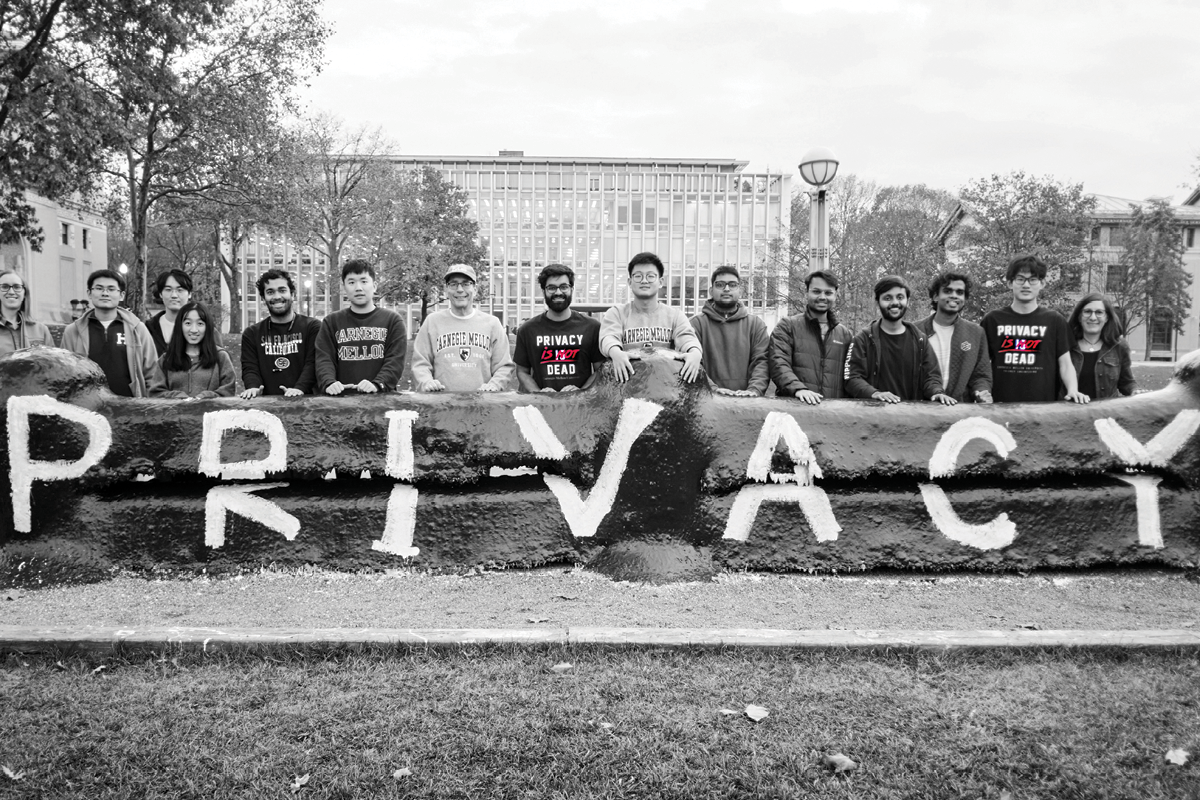 Group standing in front of the fence with PRIVACY painted on.