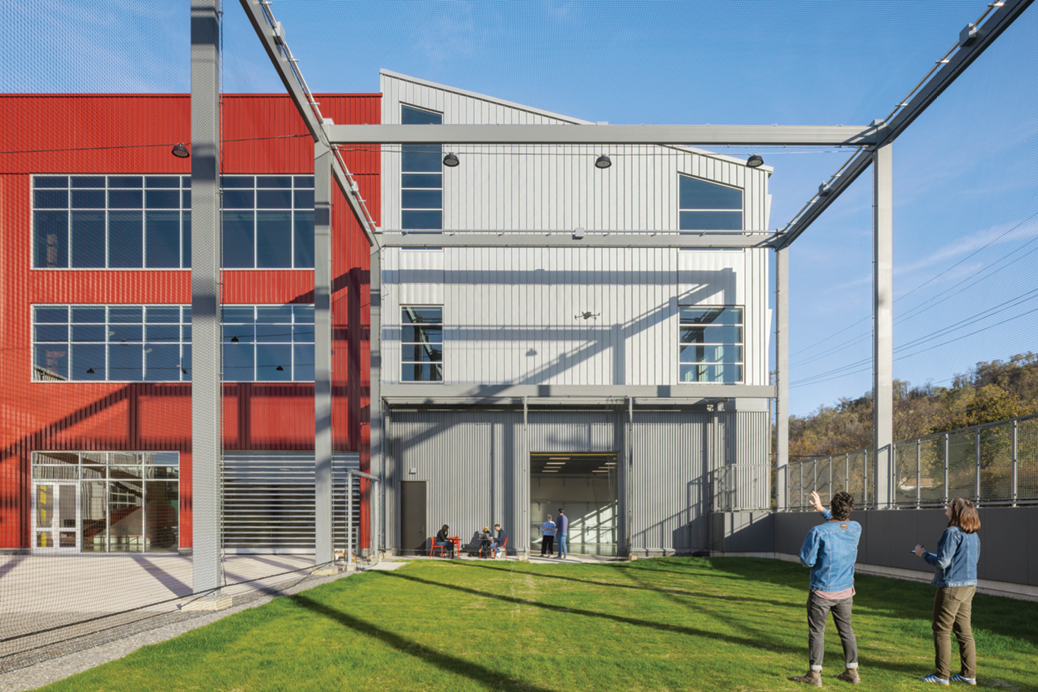 Two students fly a drone in the RIC’s exterior drone cage.