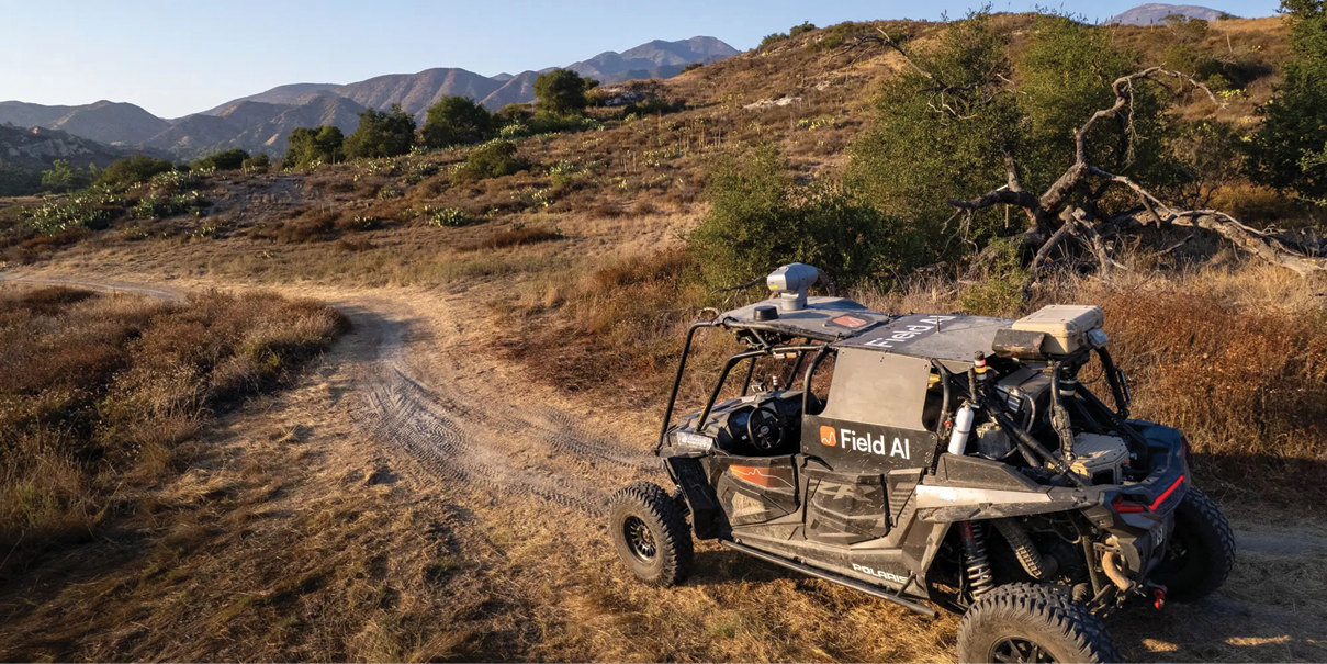 A FieldAI self driving vehicle  traverses a dirt road in California.