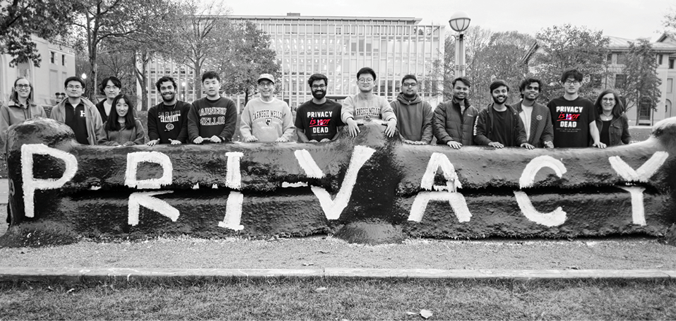 Students standing behind the fence with the word Privacy painted on.