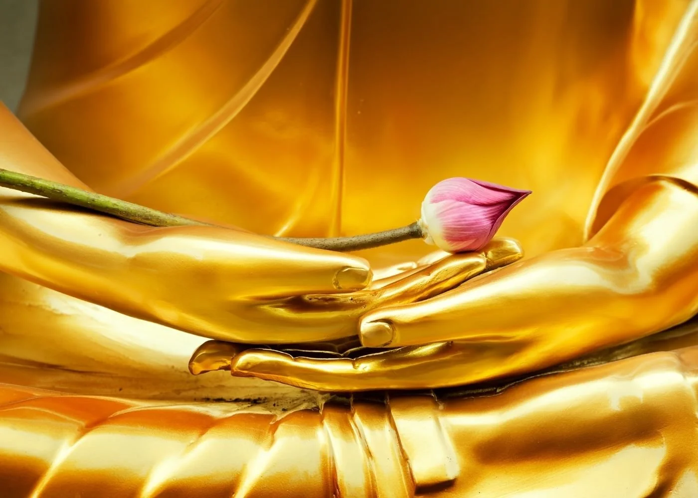 Golden Buddha with pink lotus bud.