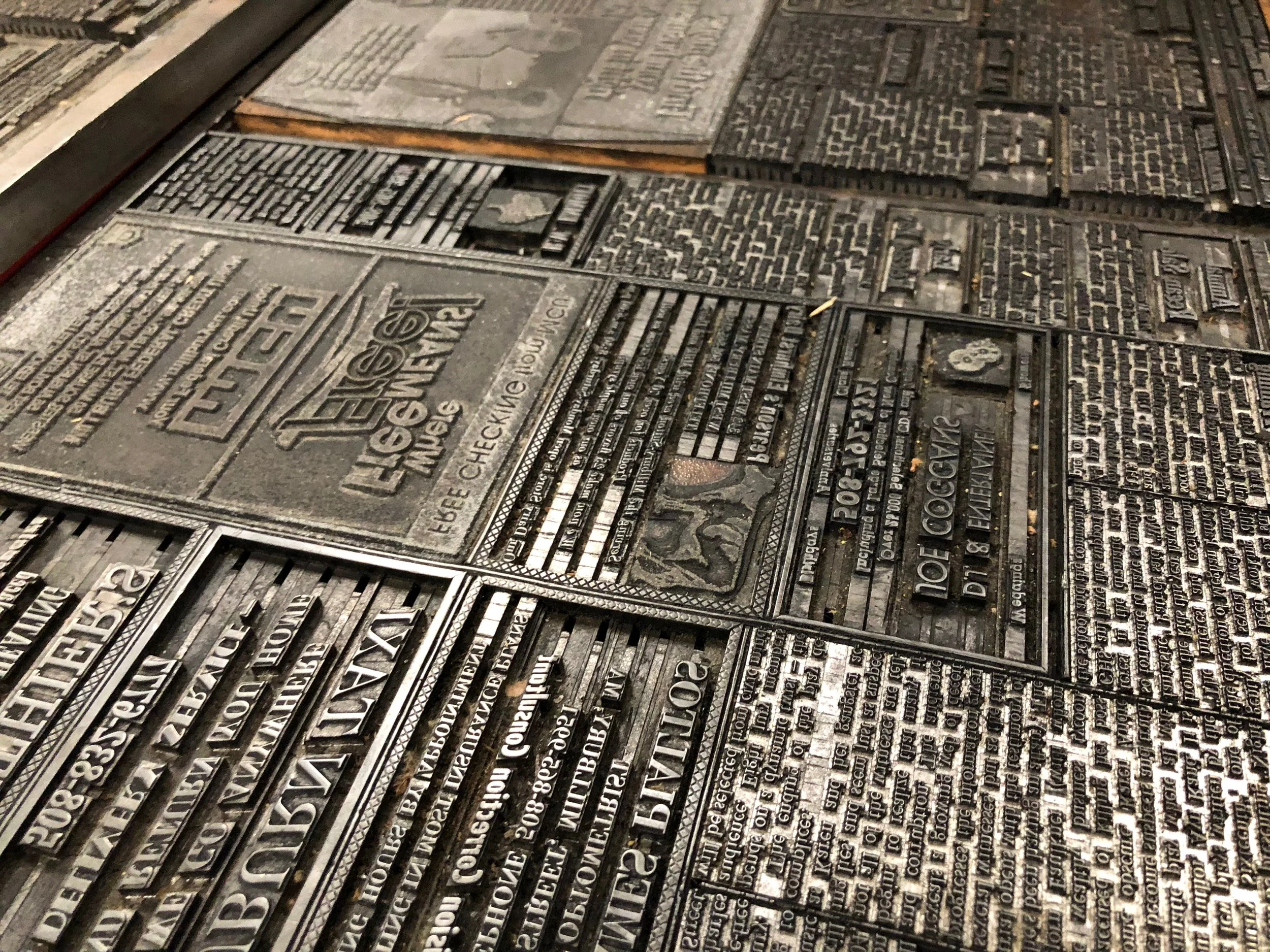Close-up of metal plaques with inscriptions, arranged on a wall, displaying text in Russian, commemorating events or people.