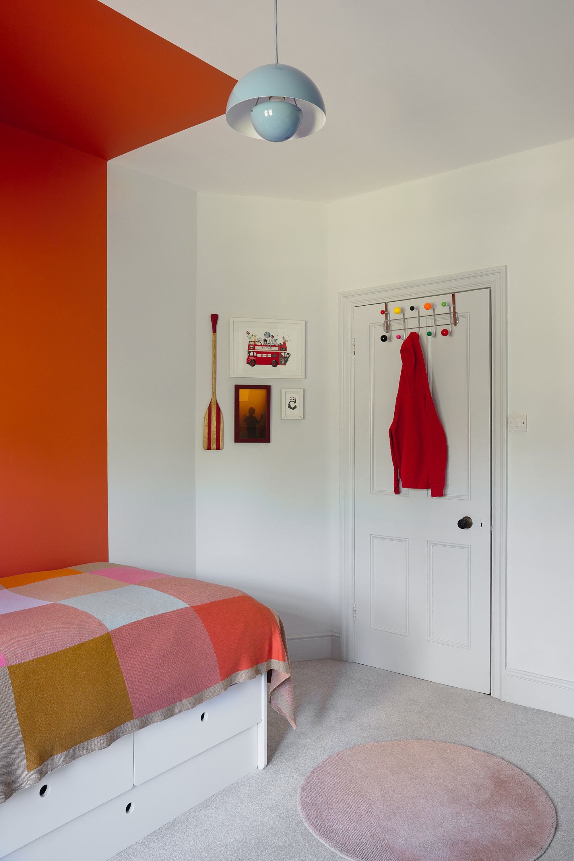 corner-of-kids-bedroom-with-orange-wall-and-chequered-blanket.jpg