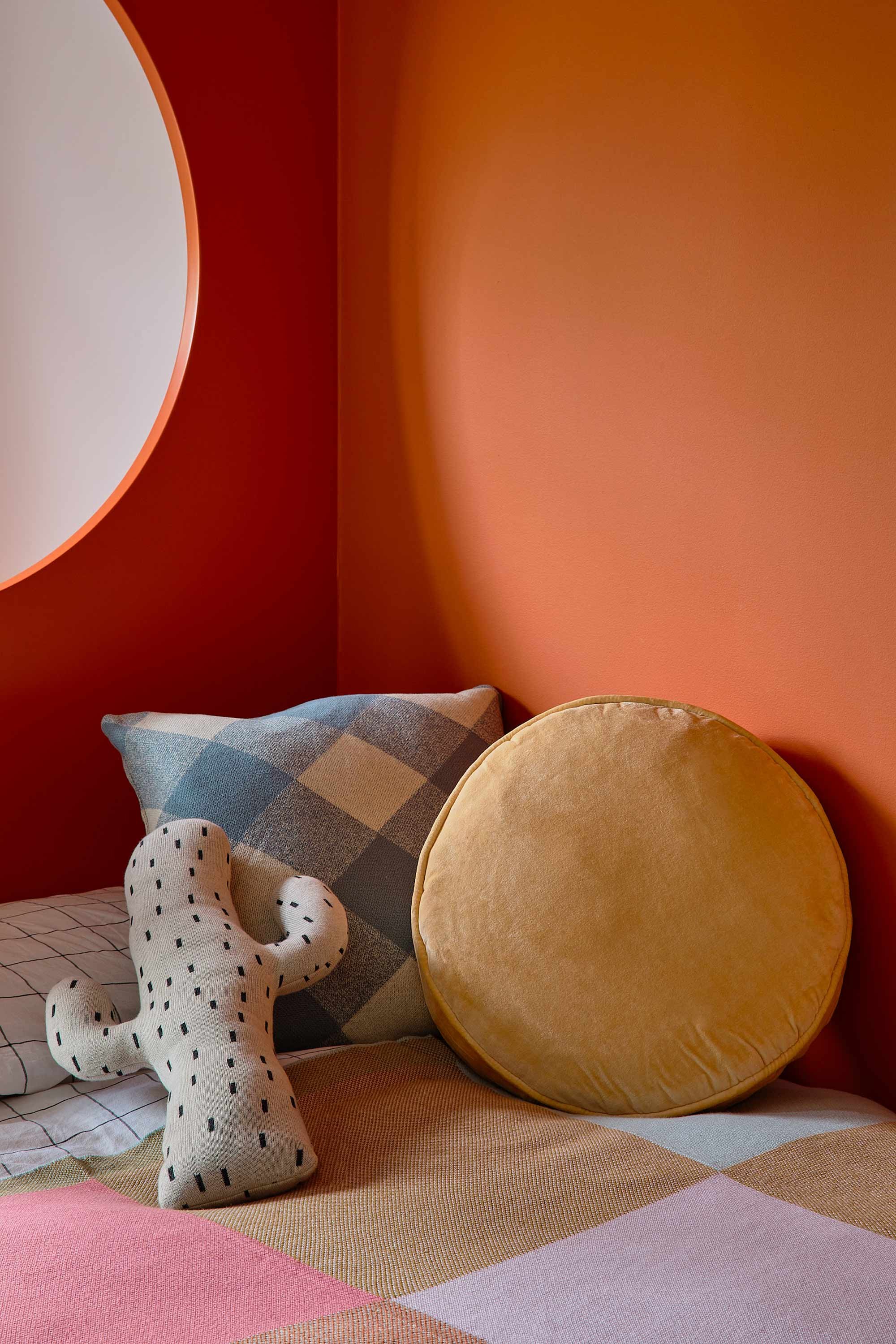 orange-bedroom-wall-close-up-with-cushions-on-bed.jpg