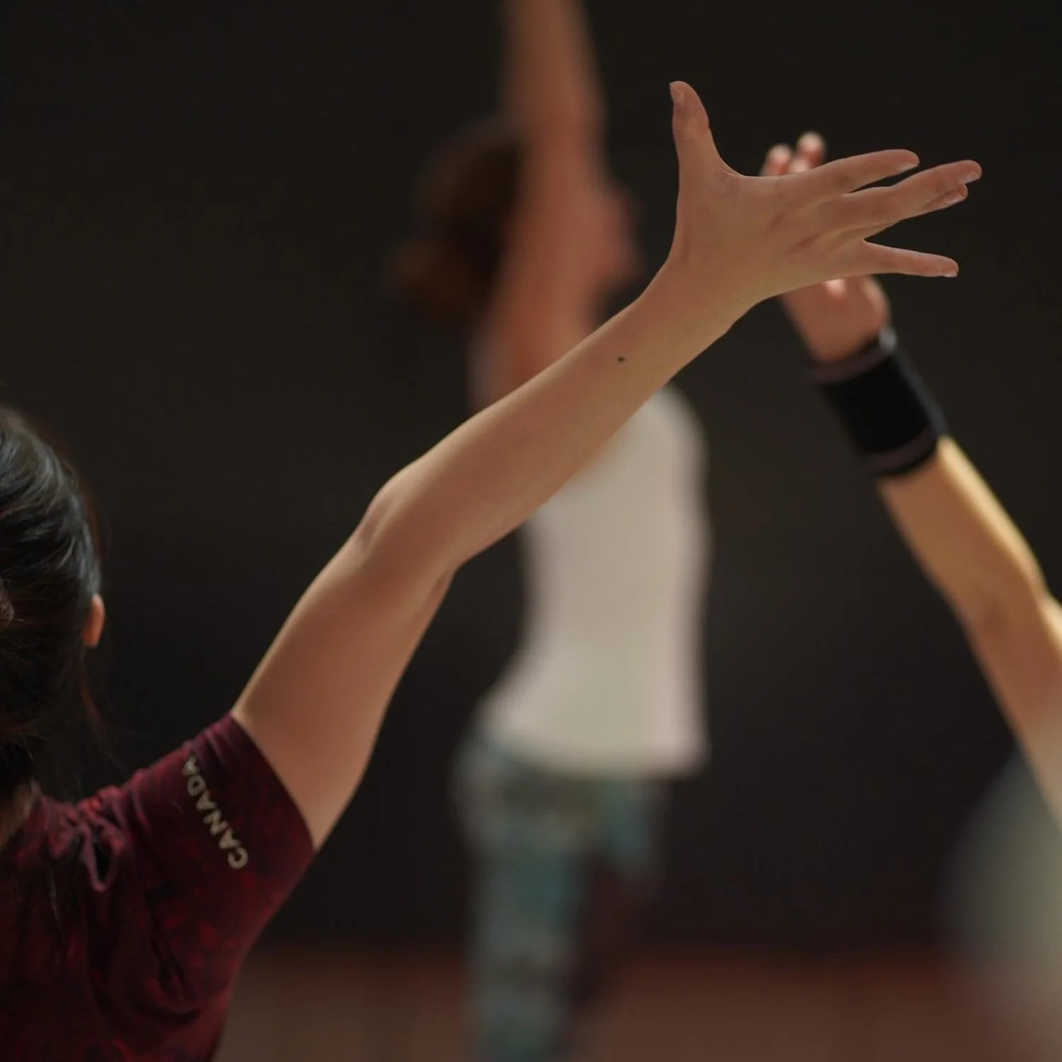 En person reser sig med armarna utsträckta under en träningsklass. Cecilia Douglas är tränare.