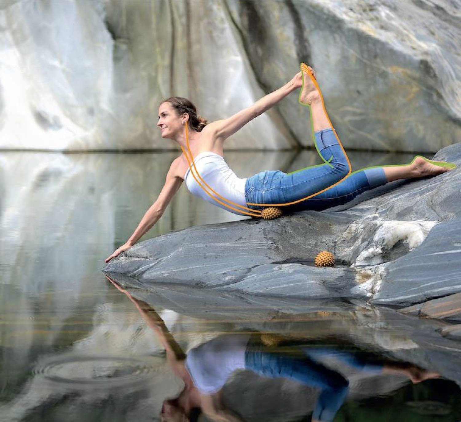 En kvinna som utför yoga på en sten vid vattnet, med en vacker naturlig bakgrund.