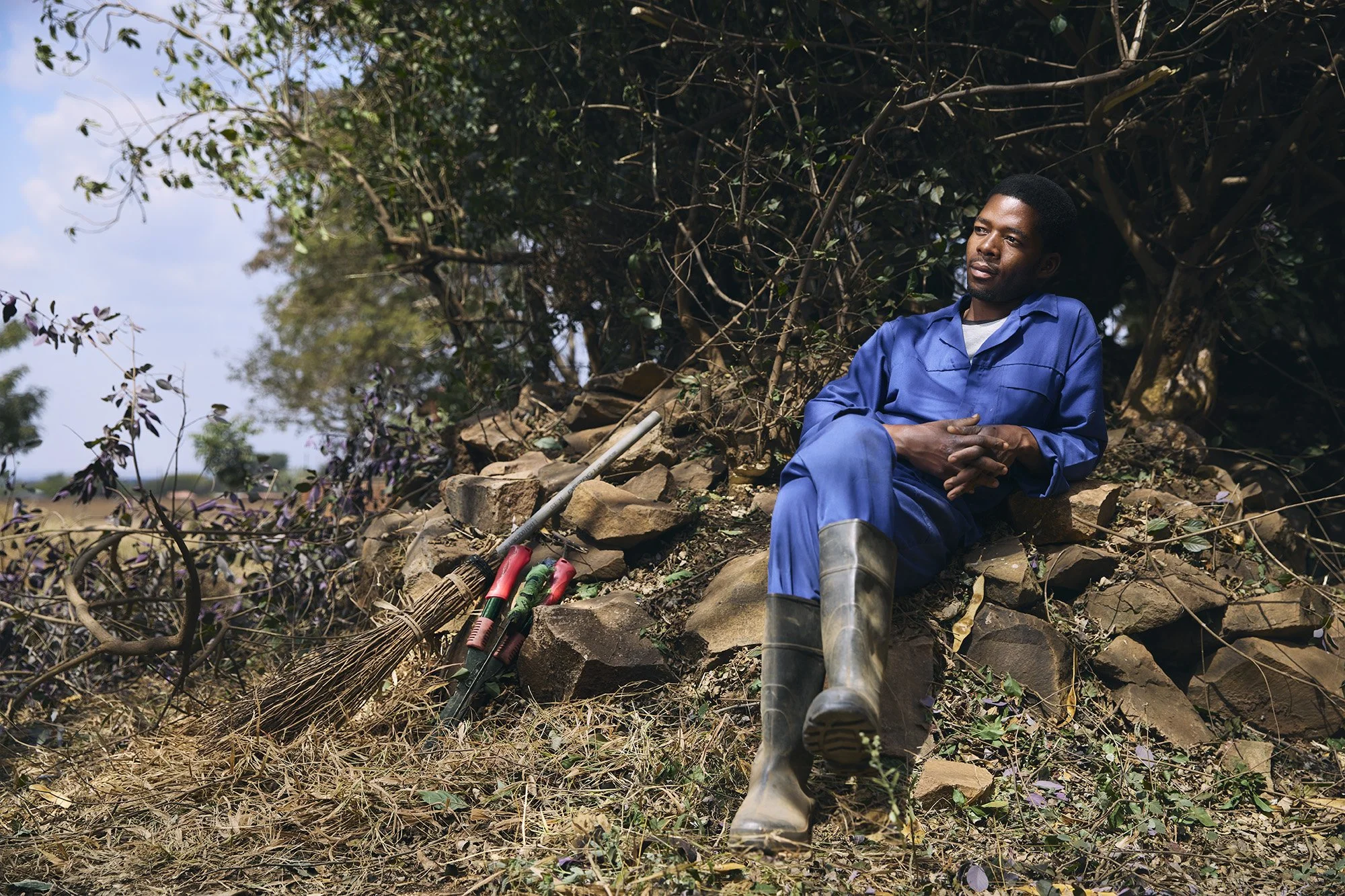 photograph of malawian man sitting in garden in shade