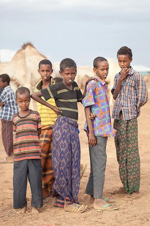 photograph of boys and camels in desert in ethiopia