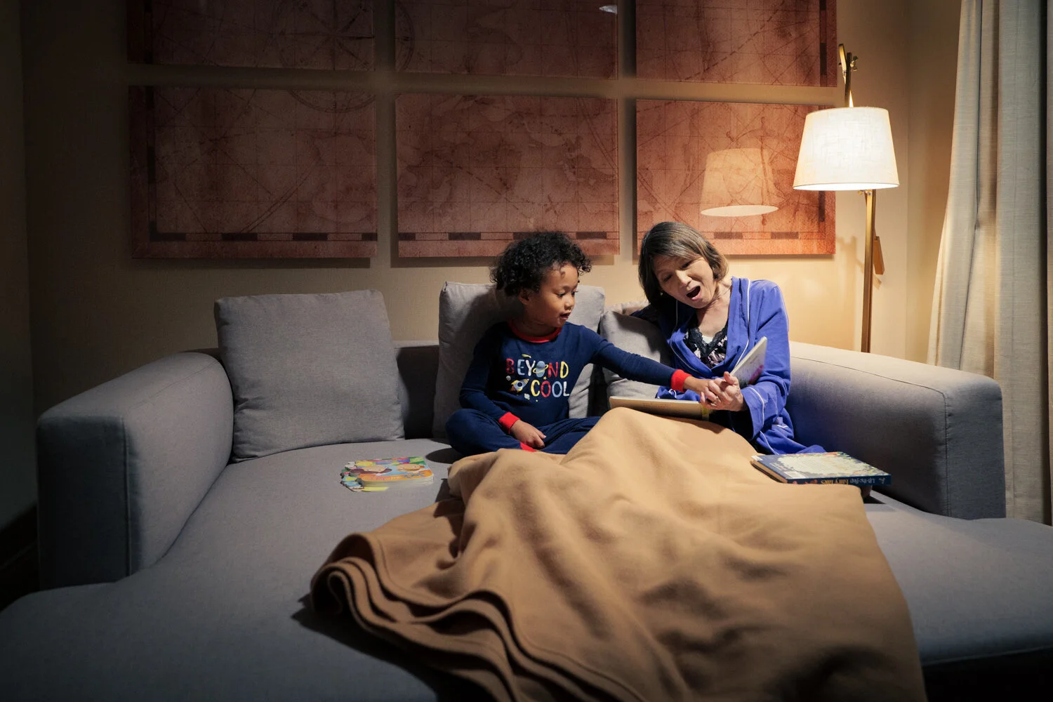 photograph of grandmother and grandson reading on couch at night © brian carlson