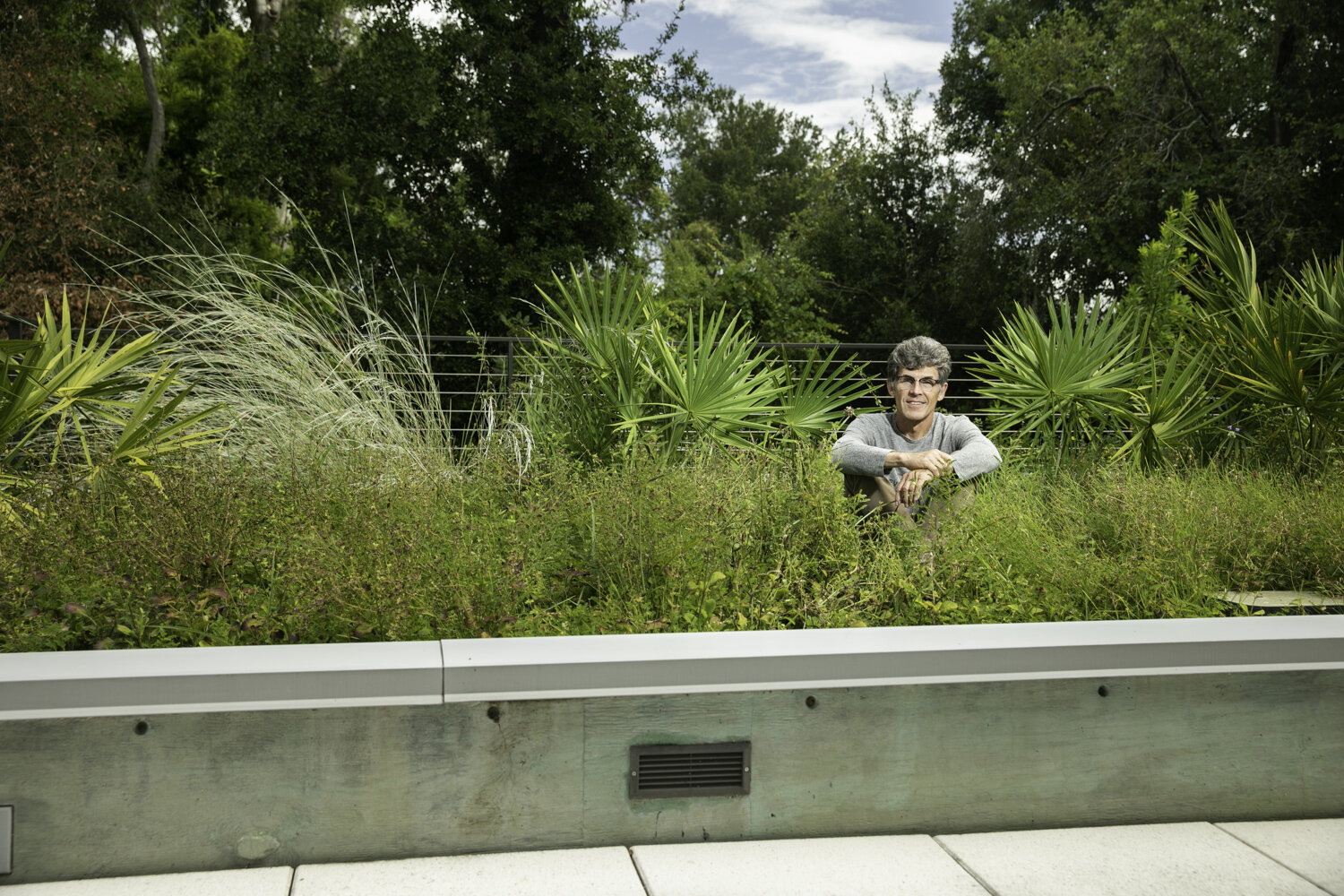 photograph of Ken LaRoe in tall grass at bank