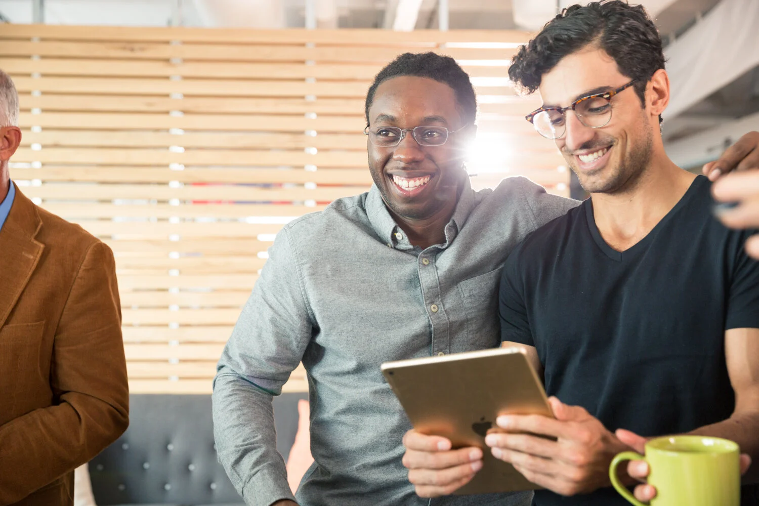 Photograph of coworkers laughing together with ipad