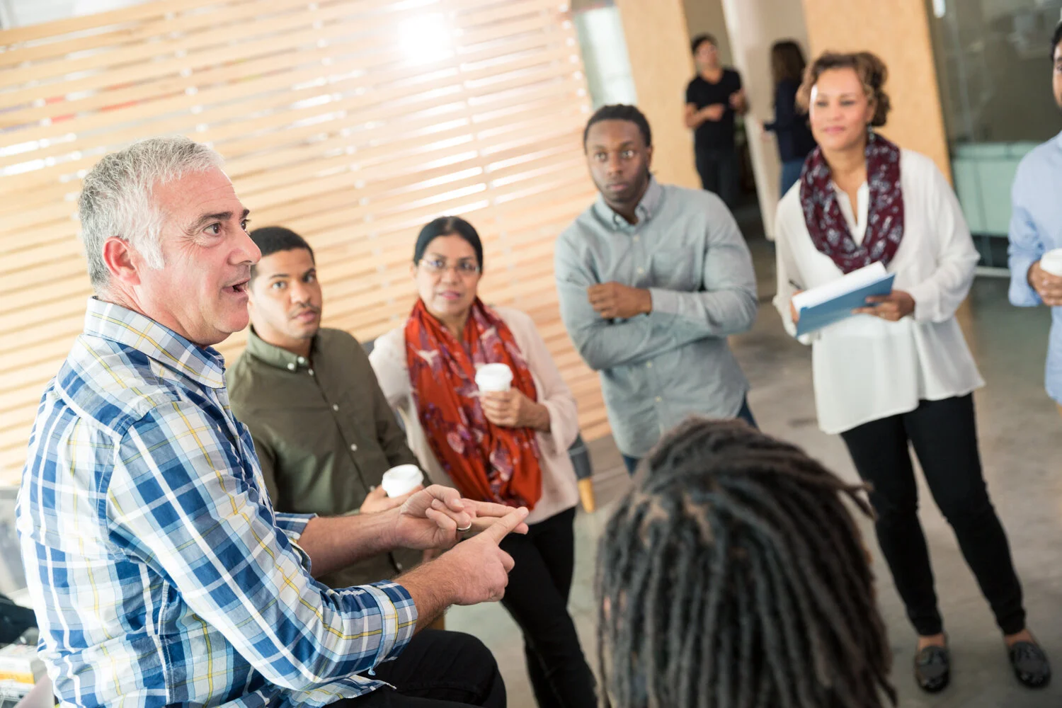 Photograph of team meeting with boss at tech company