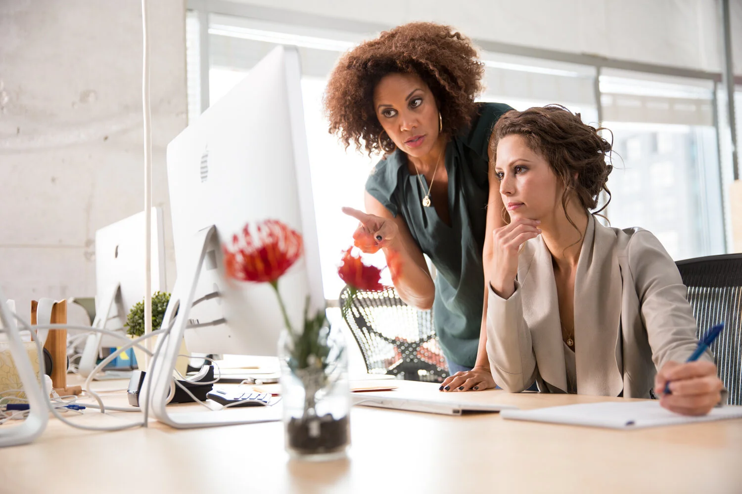 Photograph of female boss showing employee computer 