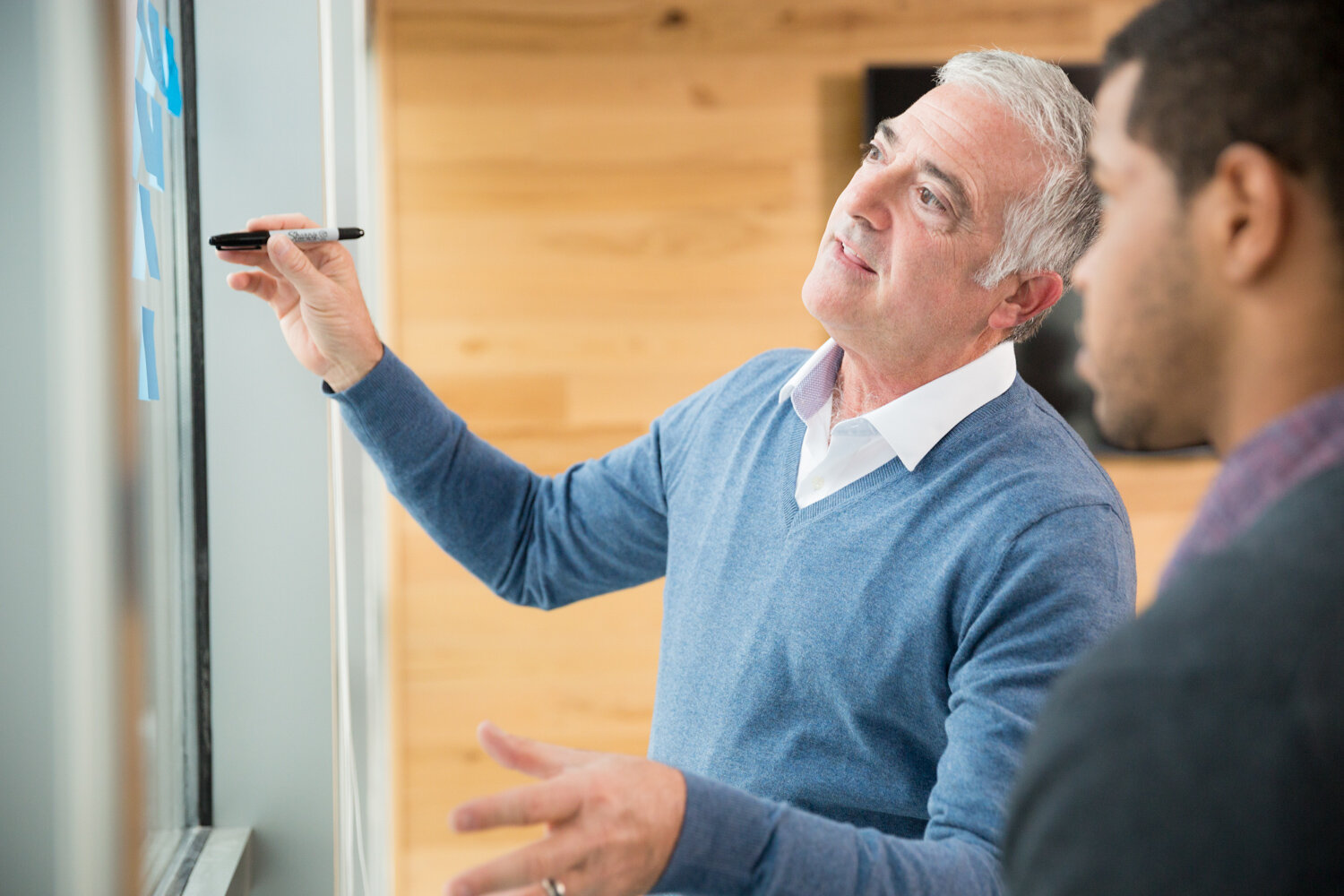 Photograph of boss showing employee idea board