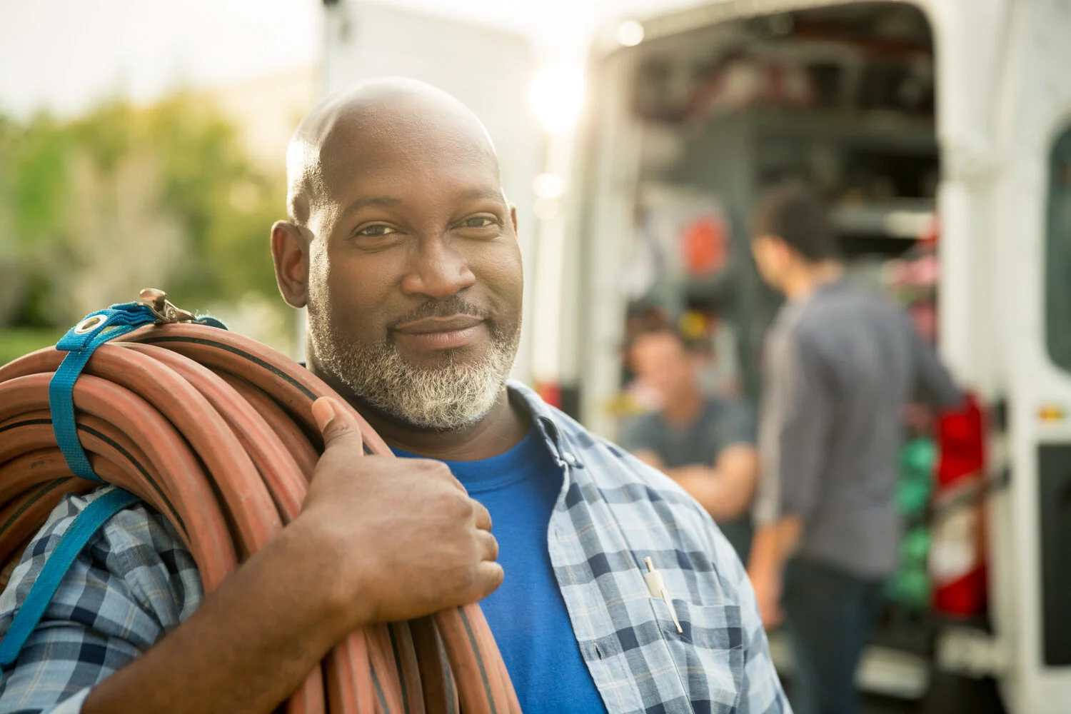 Photograph of african american male holding hose