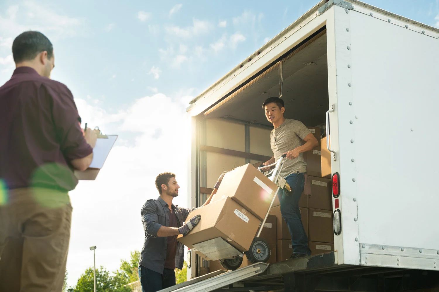 Photograph of men unloading truck under supervision