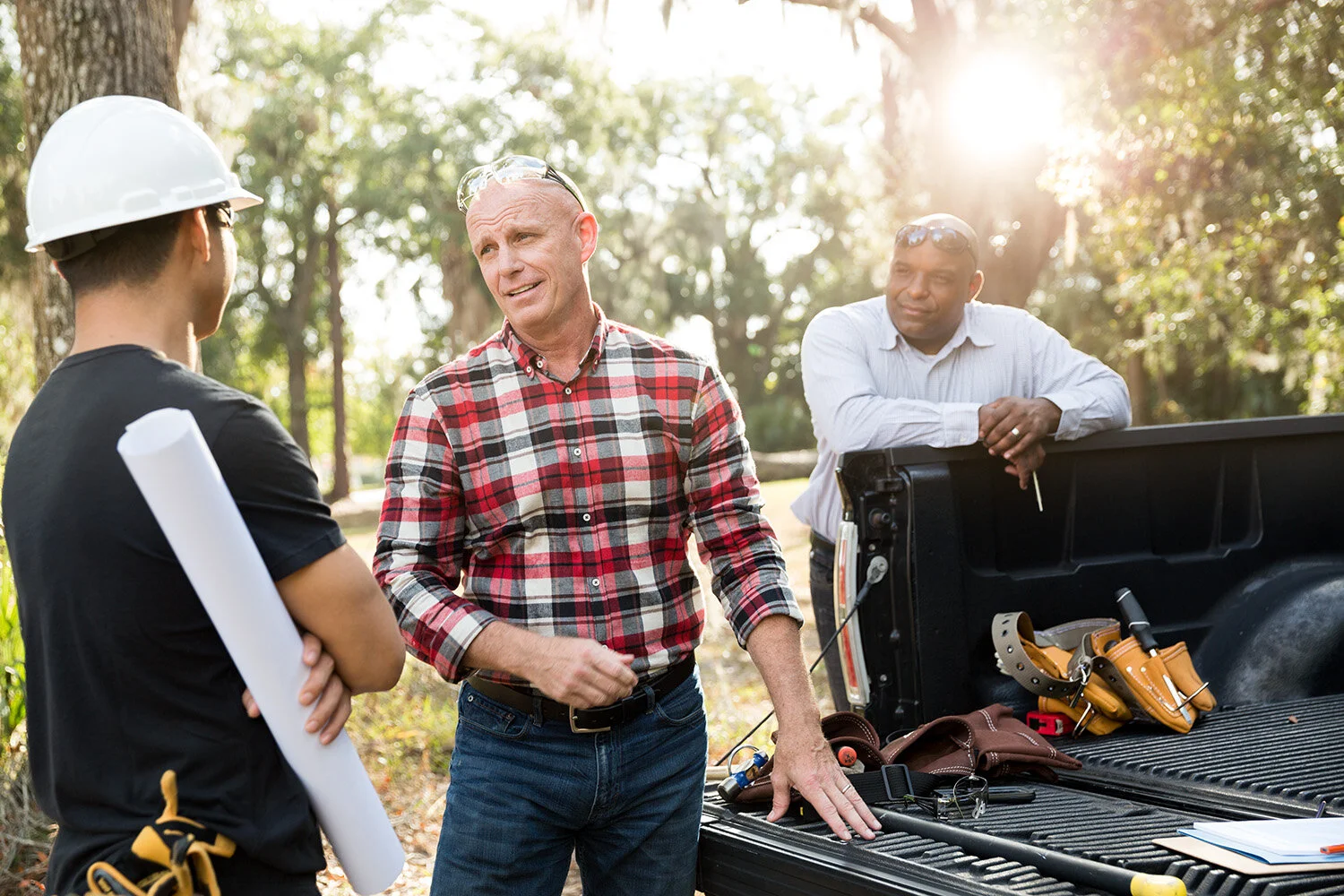 Photograph of men at back of truck talking at construction site