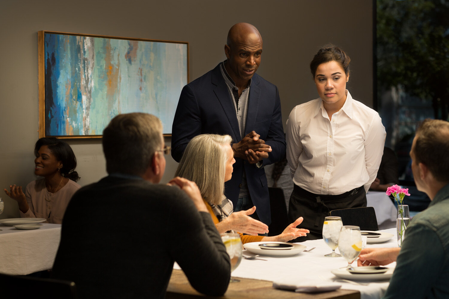 Photograph of restaurant owner talking with patrons