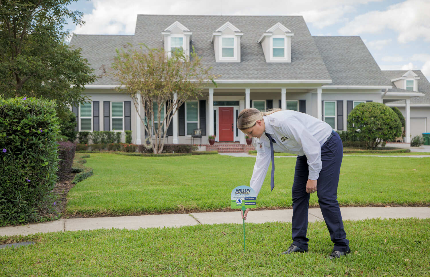Massey Services technician installing sign in front yard