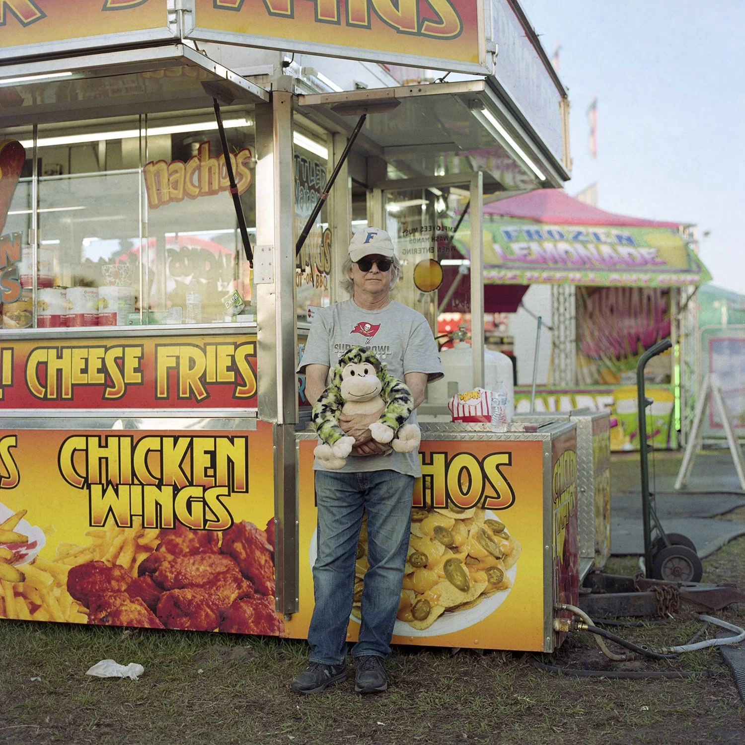 photograph of man with stuffed animal at carnival