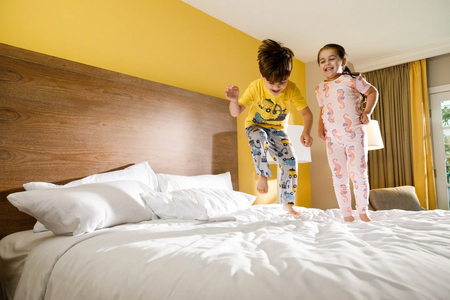 children jumping on hotel resort bed