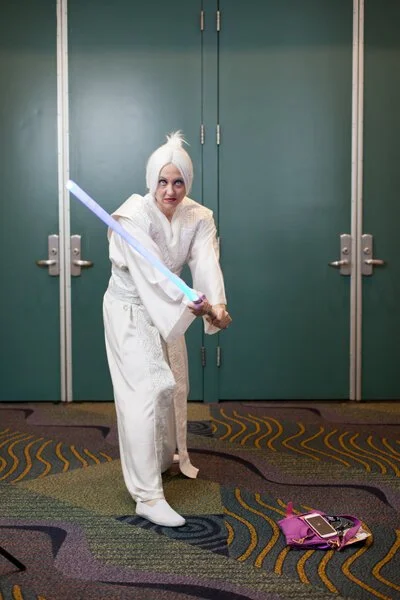 photograph of woman posing with light saber