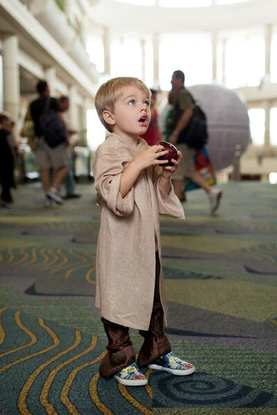 photograph of boy eating apple at star wars convention